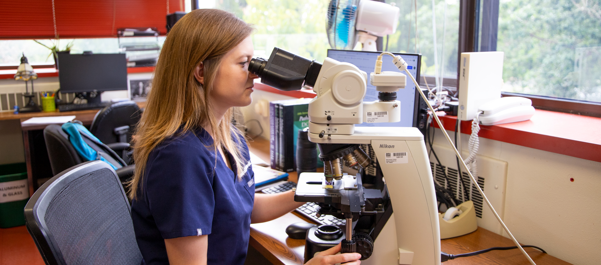 Dr. Rachael Gruenwald examines a microscopic slide. 