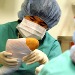 An enthusiastic participant does a fine job putting a cast on a fake dog leg after "surgery".