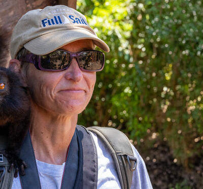 Dr. Löhr with a black lemur on her shoulder.