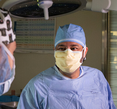 Surgeon discusses a case with veterinary student in an operating room. 
