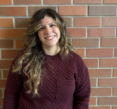 Dr. Tesas stands in front of brick wall.