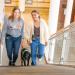Emmie and Erin walk with Newton up stairs in the college atrium
