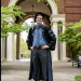 Dr. Patrick Callagy in full doctoral regalia stands in front of archway of Weatherford Hall.