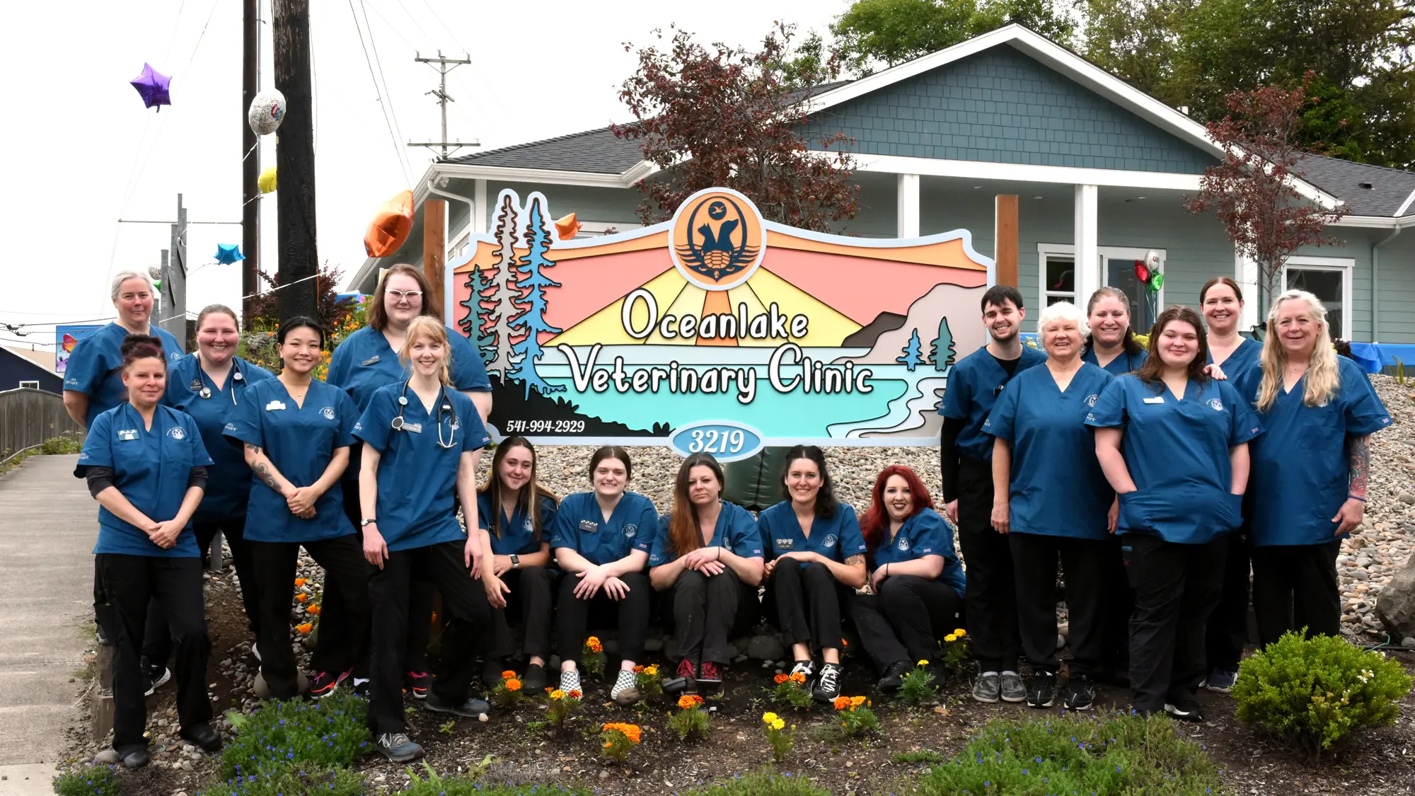 Group photo of staff surrounding Oceanlake Veterinary Clinic sign.