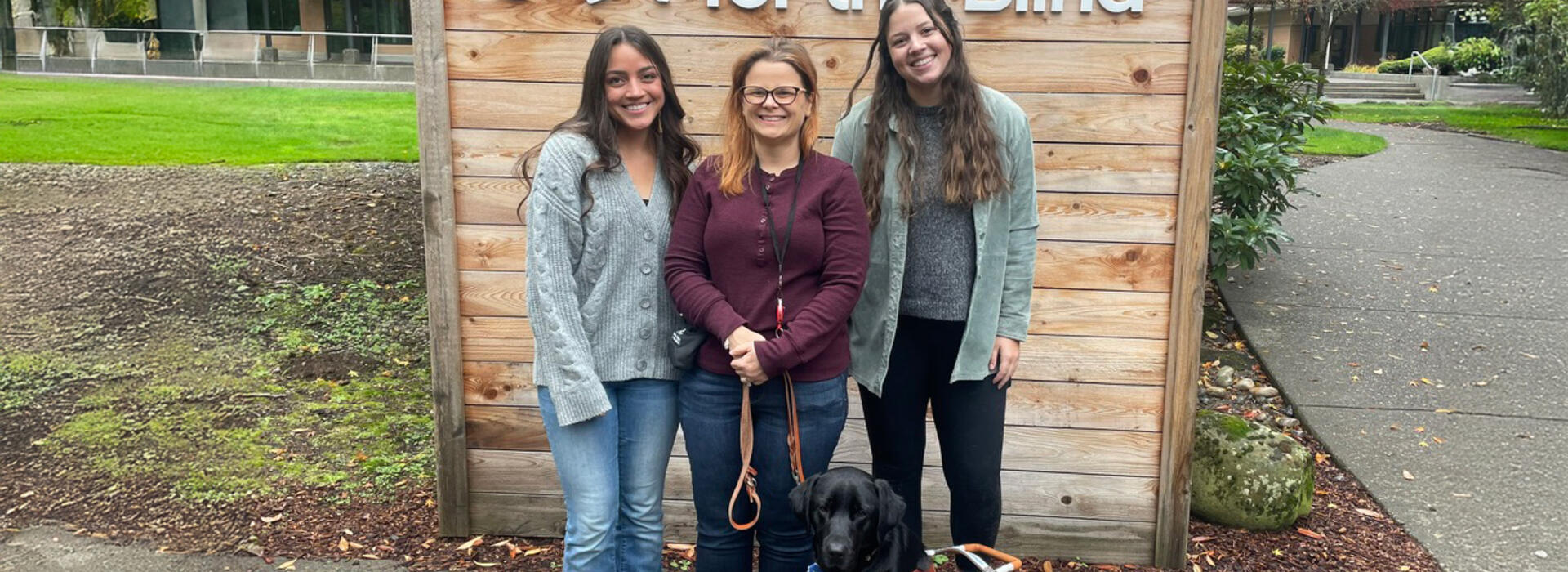 Three women and a black lab