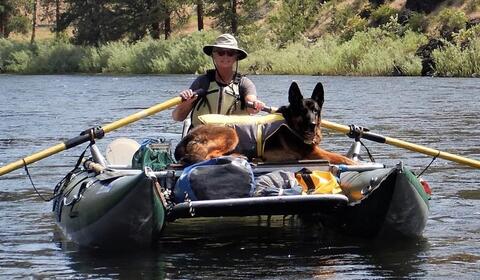 Dog and person in a river raft
