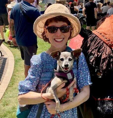 Woman in sunhat holding a dog