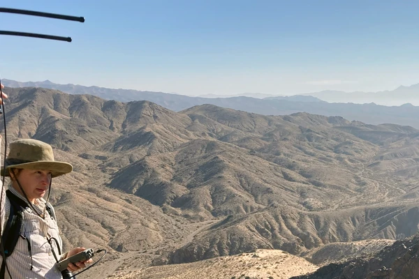 Anna Jolles holds an antenna in the Mojave desert to track bighorn sheep.