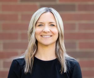 Danielle smiling in front of a brick wall