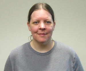 Woman smiling in a gray shirt