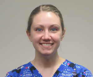 Woman smiling in blue scrubs