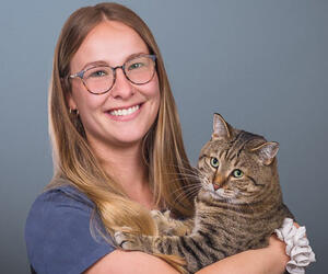 Smiling woman with glasses and a cat
