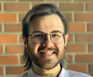 Christopher Larson portrait with brick background. 