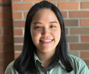 Portrait of Dr. Guan with brick background.
