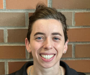 Portrait of person with brick background.