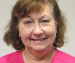 Portrait of person with gray background.
