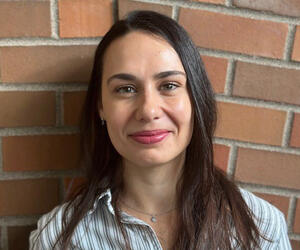 Portrait of person with brick background.