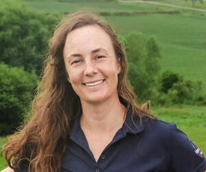 Portrait of woman outside with green hills behind. 