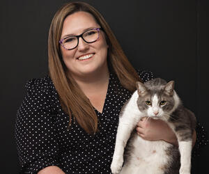 Woman smiling and holding cat.