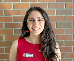 Aryana Razmara smiling with brick background.