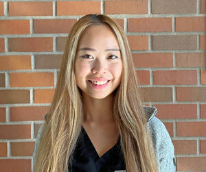 Dr. Yeung portrait with brick background.
