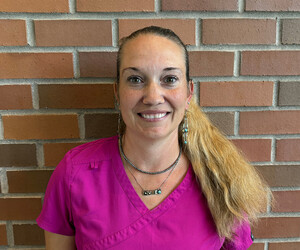 Portrait of woman in front of brick background. 