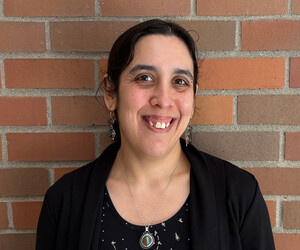 Portrait of person in front of brick background. 