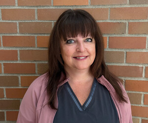 Portrait of person in front of brick background. 