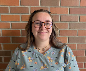 Portrait of person in front of brick background. 