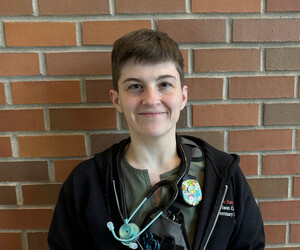 Portrait of person in front of brick background. 