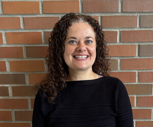 Portrait of person with brick background.
