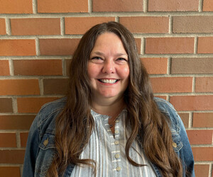 Portrait of person with brick background.