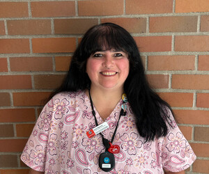 Portrait of person in front of brick background.