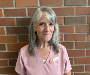 Portrait of person with brick background.