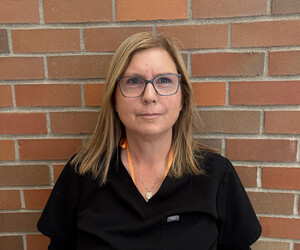 Portrait of person with brick background.