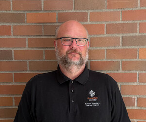 Portrait of person with brick background.