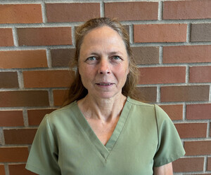 Portrait of person with brick background.