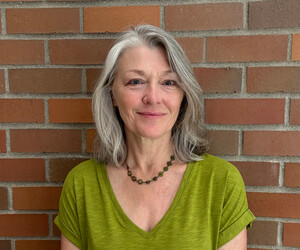 Portrait of person with brick background.