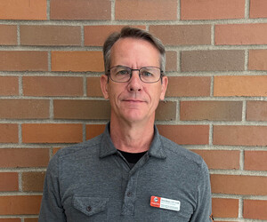 Portrait of person with brick background.