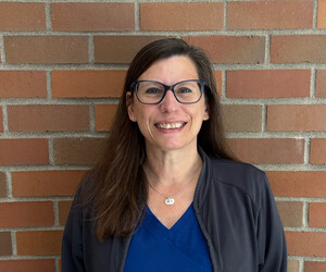 Portrait of person with brick background.