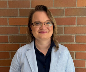 Portrait of person with brick background.
