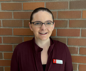 Portrait of person with brick background.