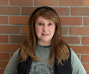 Portrait of person with brick background.