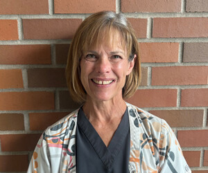 Portrait of person with brick background.