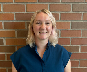 Portrait of person with brick background.
