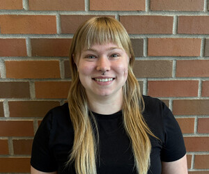 Portrait of person with brick background.